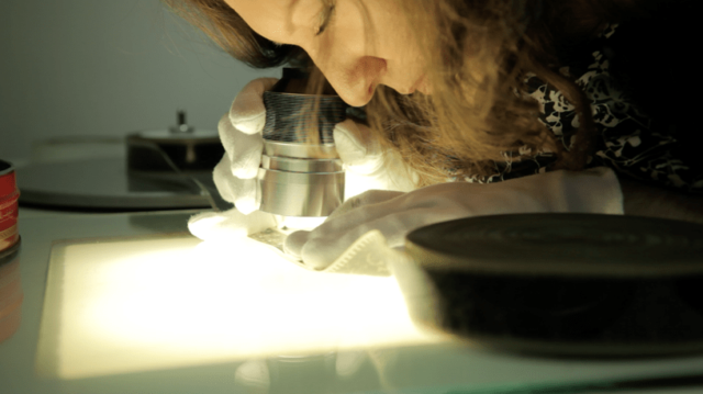 A person looks down the microscope at Yorkshire Film Archive