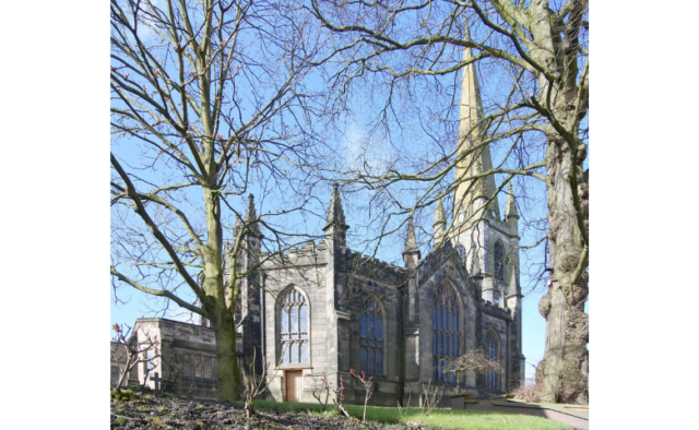 St Thomas and St Luke church, Dudley - a grey stone church with a square tower and spire surrounded by trees