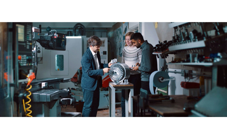 Three people examine an engine in the Whittle Laboratory at the University of Cambridge
