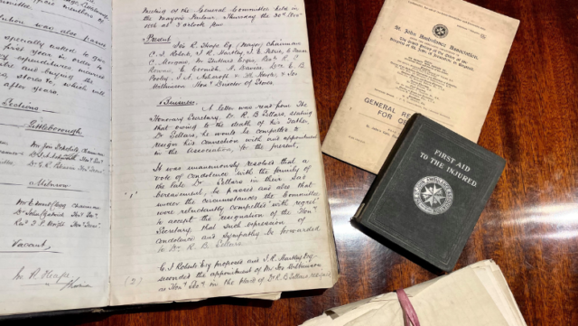 A handwritten letter and other documents laid out on a wooden table.