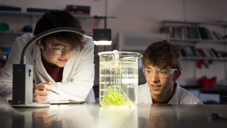 Students at The Queen Katherine School. Credit: Jon Hayes Two students wearing goggles watch a science experiment in a laboratory.